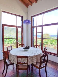 una sala da pranzo con tavolo, sedie e finestre di Casa dos Magalhães a Vila do Porto