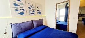 een slaapkamer met een blauw bed en een spiegel bij Casa Pomonte in Pomonte