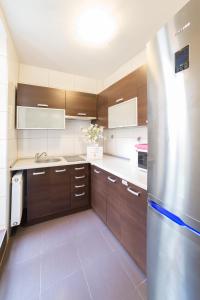 a kitchen with wooden cabinets and a stainless steel refrigerator at Green Hostel in Toruń