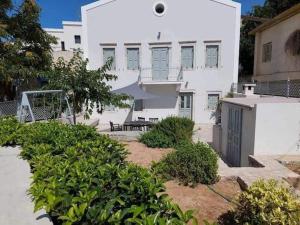 a large white building with a bench in front of it at Villa Calliope in Kalymnos