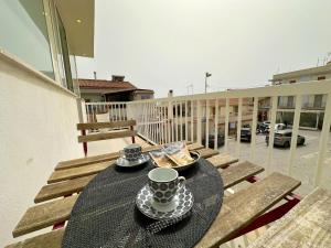 una mesa en un balcón con una taza de café en Portosalvo Holiday House, en Marina di Ragusa