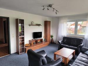 a living room with two couches and a tv at Haus Christine in Halblech