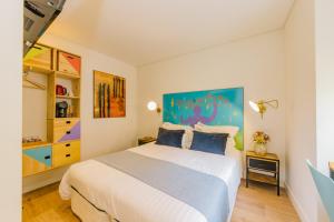 una camera da letto con un grande letto bianco con testiera blu di Bairro Alto Music Guest House a Lisbona