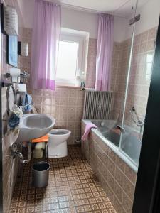 uma casa de banho com um lavatório, uma banheira e um WC. em Haus Christine em Halblech