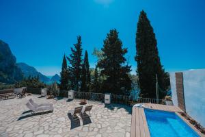 un patio con piscina, sillas y árboles en Villa La Baika - Pool Panoramic views, en Capri