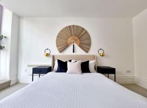 a bedroom with a large white bed with a large fan on the wall at The Stray adjacent, Interior-Designed 2-bed Apartment- Luxury in Harrogate