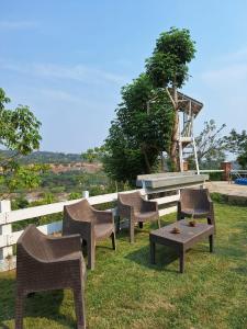 La Cabaña ideal para la desconexión في Barquisimeto: مجموعة من الكراسي وطاولة في العشب