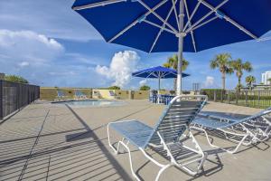 a group of chairs and umbrellas next to a pool at Phoenix 6 Unit 706 in Orange Beach