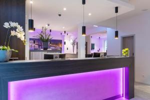 a bar with purple lighting in a lobby at CityClass Hotel am Heumarkt in Cologne