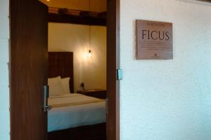 1 dormitorio con 1 cama y un cartel en la puerta en BOTANIQ HOTEL BOUTIQUE, en Valle de Bravo