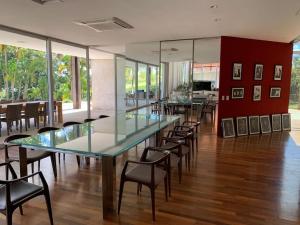 uma sala de jantar com uma mesa de vidro e cadeiras em Orla Villas Brasília em Rio Bananal