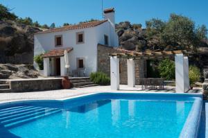 a villa with a swimming pool in front of a house at Quinta da Saimeira in Marvão