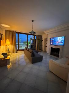 Una sala de estar con un sofá y un televisor. en Roof Apartment, en Somma Vesuviana