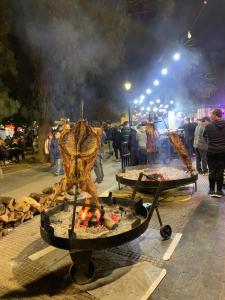 a crowd of people standing around a fire grill at HOTEL EXPRESS MENDOZA in Mendoza