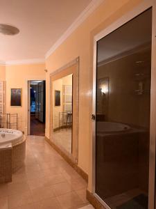 ein Badezimmer mit einer Badewanne und einem großen Spiegel in der Unterkunft Roof Apartment in Somma Vesuviana