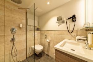 a bathroom with a shower and a toilet and a sink at CityClass Hotel am Heumarkt in Cologne