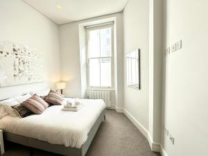 - une chambre blanche avec un lit et une fenêtre dans l'établissement Chic apartment in Queensway for six guests, à Londres