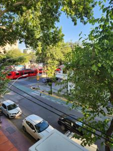 門多薩的住宿－HOTEL EXPRESS MENDOZA，一条有汽车和红色巴士的城市街道
