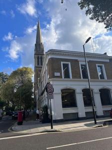 un bâtiment avec une cloche d'église dans une rue de la ville dans l'établissement Chic apartment in Queensway for six guests, à Londres
