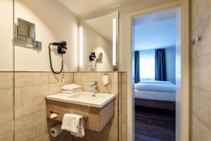 a bathroom with a sink and a mirror at CityClass Hotel am Heumarkt in Cologne
