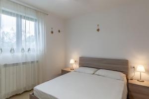 Un dormitorio blanco con una cama grande y una ventana. en Ca' Graziosi Cuori, en Bagnone