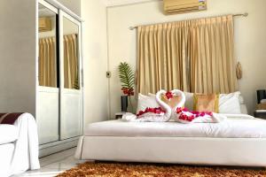 dwa białe łabędzie siedzące na łóżku w sypialni w obiekcie OASIS VILLA Suites & Rooms w mieście Karon Beach