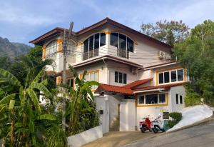una casa con una motocicleta estacionada frente a ella en OASIS VILLA Suites & Rooms, en Karon Beach