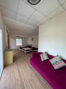 un soggiorno con divano viola e letto di C-Hill Camp&Resort a Mae Rim