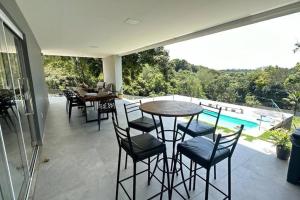 a patio with a table and chairs and a pool at Casa Retiro do Congo in Vila Velha