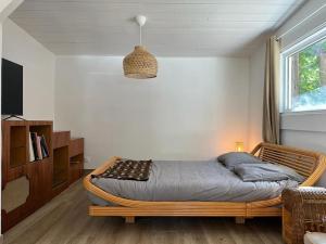 een slaapkamer met een rotan bed en een raam bij Appartement indépendant Guethary in Saint-Jean-de-Luz