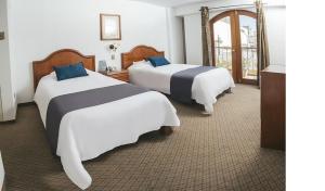 Habitación de hotel con 2 camas y ventana en Hotel Asturias, en Arequipa