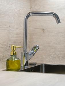 a bathroom sink with a bottle of yellow soap at Apartment Pr'pek in Bohinj