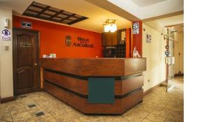 un bar en un restaurante con una pared de color naranja en Hotel Asturias, en Arequipa