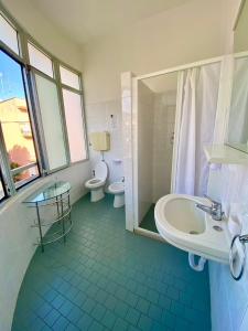 a bathroom with two toilets and a sink and a shower at Hotel Villa Pozzi in Cattolica