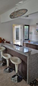 a kitchen with a large counter with bar stools at Casa Condominio Papudo Punta Puyai 3 dormitorios in Papudo