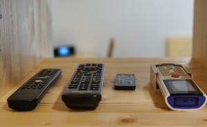four remote controls sitting on top of a wooden shelf at Apartment Pr'pek in Bohinj