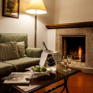 a living room with a fireplace and a table with wine glasses at Pousada de Marvao in Marvão