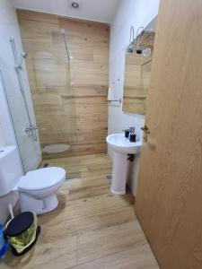 uma casa de banho com um WC branco e um lavatório. em Bojana Apartment Penthouse em Negotino