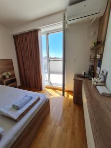 um quarto com uma cama e uma grande janela em Bojana Apartment Penthouse em Negotino