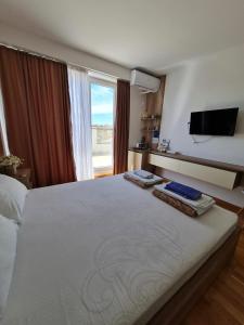 a bedroom with a large bed with a flat screen tv at Bojana Apartment Penthouse in Negotino