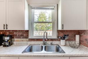 マンシーにあるBright Muncie Home with Yard about 2 Mi to Downtown!のシンクと窓のあるキッチンカウンター +17枚の写真