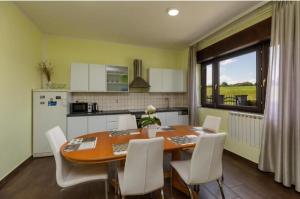 a kitchen with a wooden table and white chairs at Apartment Karlovac in Karlovac