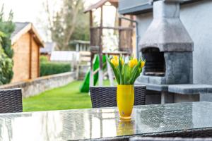 a yellow vase with yellow flowers sitting on a table at Ferienhaus Sieger in Salem