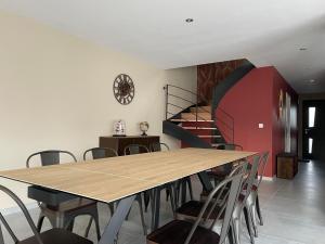 a dining room with a table and chairs and a staircase at Villa avec piscine, à 5 minutes de la plage. Idéal pour vacances en famille et amis in Plouhinec