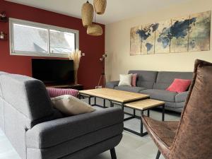 a living room with two couches and a table at Villa avec piscine, à 5 minutes de la plage. Idéal pour vacances en famille et amis in Plouhinec