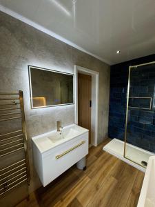 a bathroom with a white sink and a shower at Chequers Inn in Harrogate