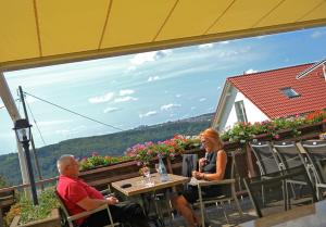 um homem e uma mulher sentados numa mesa numa varanda em Hotel-Restaurant Kelter em Esslingen