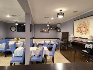 a dining room with tables and blue chairs at Pensiunea Vila Chesa in Corunca +21 photos