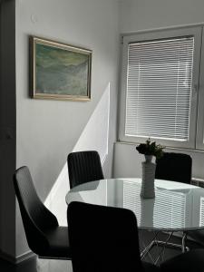 ein Esszimmer mit einem Glastisch und Stühlen in der Unterkunft Ivanov Apartment in Bitola