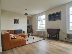 uma sala de estar com um sofá e uma mesa em Trinity Square Loft + sea views em Kent